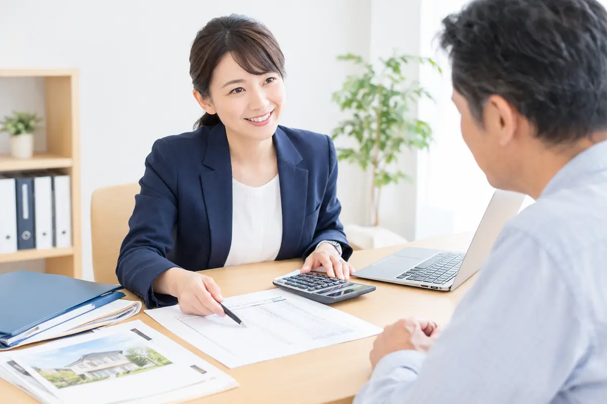 税理士が書類と電卓を前に、相続税申告の費用を相談者に説明しているイメージ